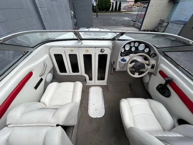Slide: The Image of 2004 Stingray 220 CS boat interior with white seating and dashboard controls. - 12
