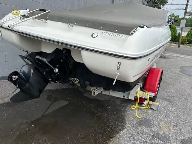 Slide: The Image of 2004 Stingray 220 CS boat on trailer, covered and parked outdoors. - 5