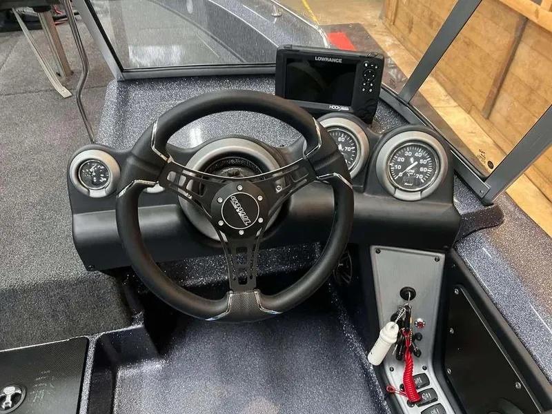 Slide: The Image of 2024 Triton 186 Allure boat dashboard with steering wheel, gauges, and Lowrance display. - 3