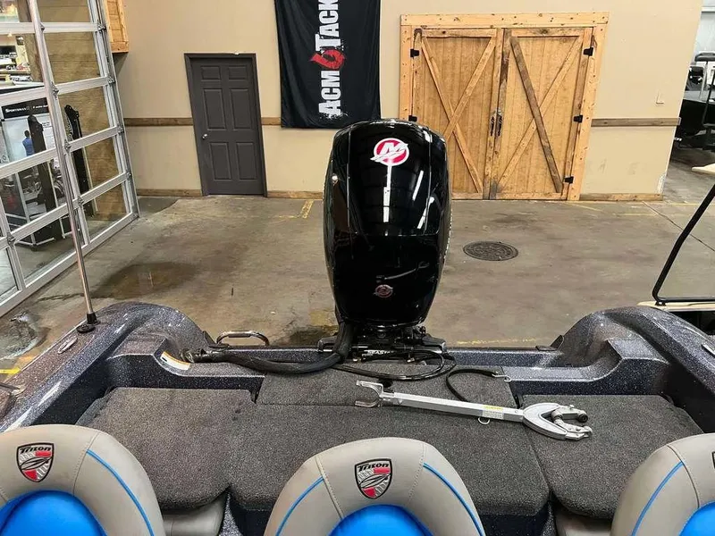 Slide: The Image of 2024 Triton 186 Allure boat interior with motor, in a showroom setting. - 7