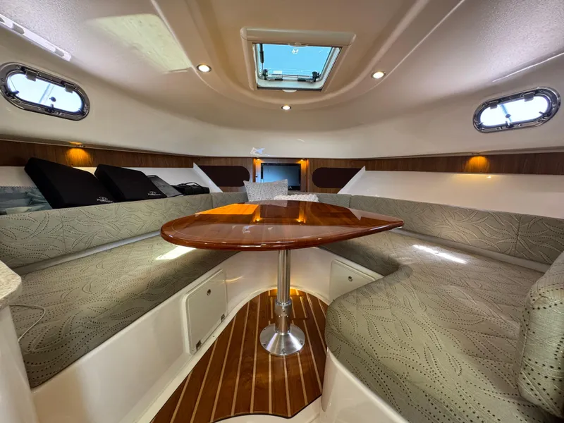 Slide: The Image of 2014 Pursuit 345 OS cabin interior with elegant seating and wooden table. - 11