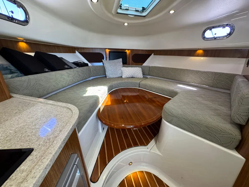 Slide: The Image of Luxurious interior of 2014 Pursuit 345 OS boat with elegant seating and wooden table. - 12