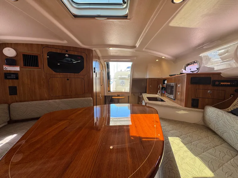 Slide: The Image of 2014 Pursuit 345 OS cabin interior with wood finishes and modern amenities. - 16