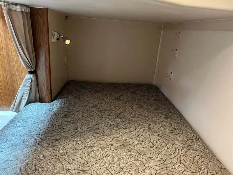 Slide: The Image of 2014 Pursuit 345 OS cabin interior with patterned bedding and reading light. - 20