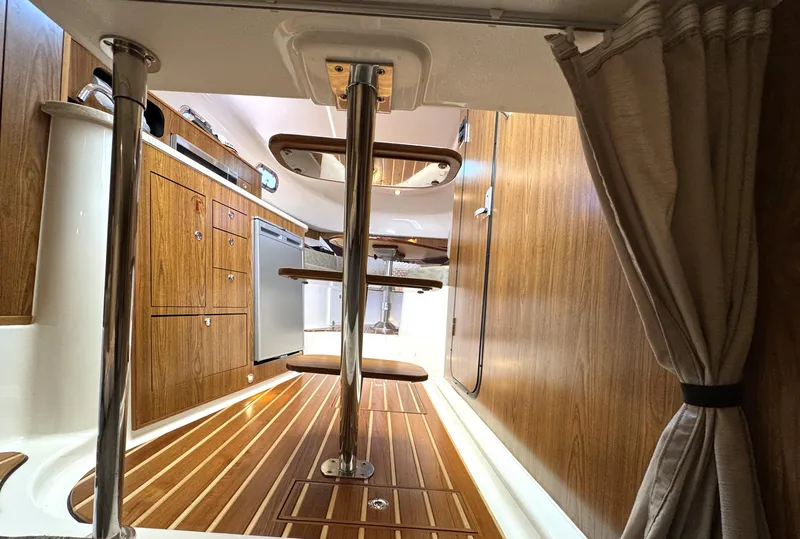 Slide: The Image of Interior of 2014 Pursuit 345 OS boat with wooden cabinetry and flooring. - 24