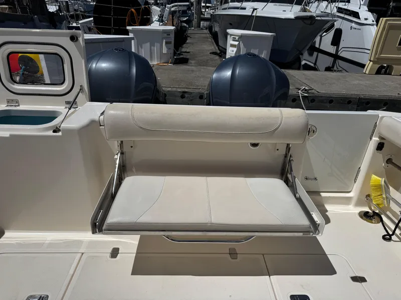 Slide: The Image of 2014 Pursuit 345 OS boat with foldable seat and twin outboard motors at dock. - 26