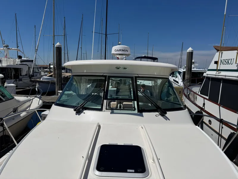 Slide: The Image of 2014 Pursuit 345 OS boat docked at marina with clear blue sky. - 33
