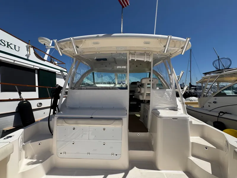 Slide: The Image of 2014 Pursuit 345 OS boat docked at marina under clear blue sky. - 37