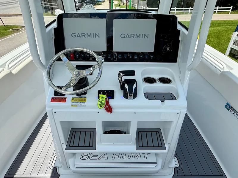Slide: The Image of 2023 Sea Hunt Ultra 255 SE boat console with dual Garmin displays and steering wheel. - 10