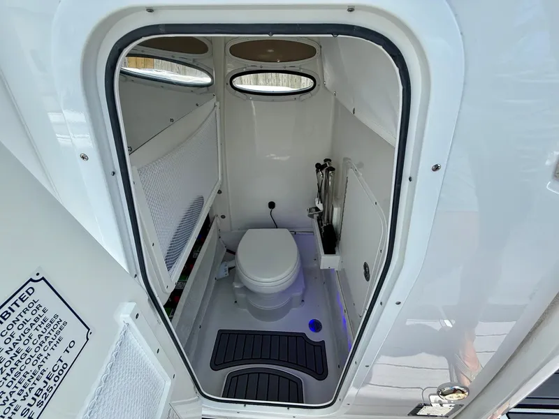 Slide: The Image of 2023 Sea Hunt Ultra 255 SE boat interior with compact marine toilet. - 13