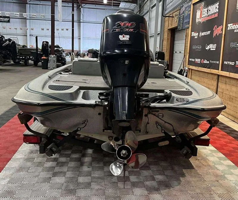 Slide: The Image of 2000 Triton TR20 boat with powerful outboard motor in a showroom setting. - 3