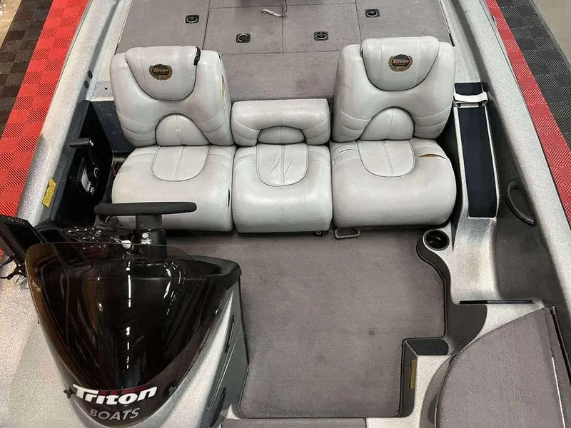 Slide: The Image of Interior of a 2000 Triton TR20 boat with gray seating and steering console. - 8