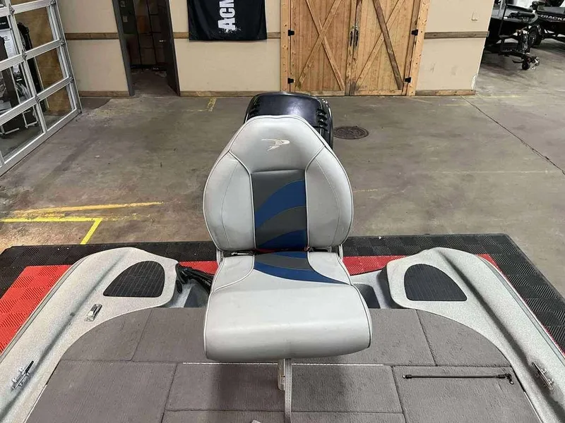 Slide: The Image of 2000 Triton TR20 boat seat in a garage setting, featuring gray and blue upholstery. - 9