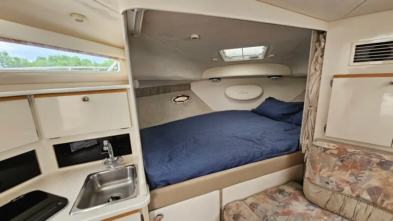 Slide: The Image of 1999 Bayliner 3055 Ciera cabin interior with bed, sink, and seating area. - 13