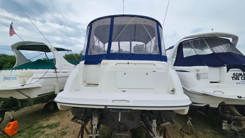 Slide: The Image of 1999 Bayliner 3055 Ciera boat on dry dock, flanked by two other boats. - 3