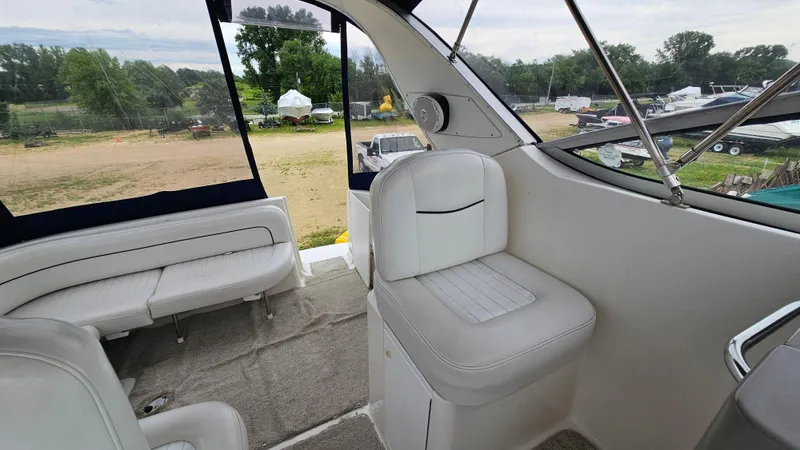 Slide: The Image of Interior of 1999 Bayliner 3055 Ciera boat with white seating and outdoor view. - 8