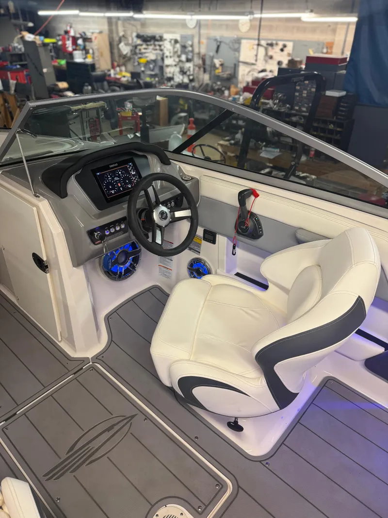 Slide: The Image of 2023 Chaparral 21 Surf boat interior with steering wheel and dashboard. - 12