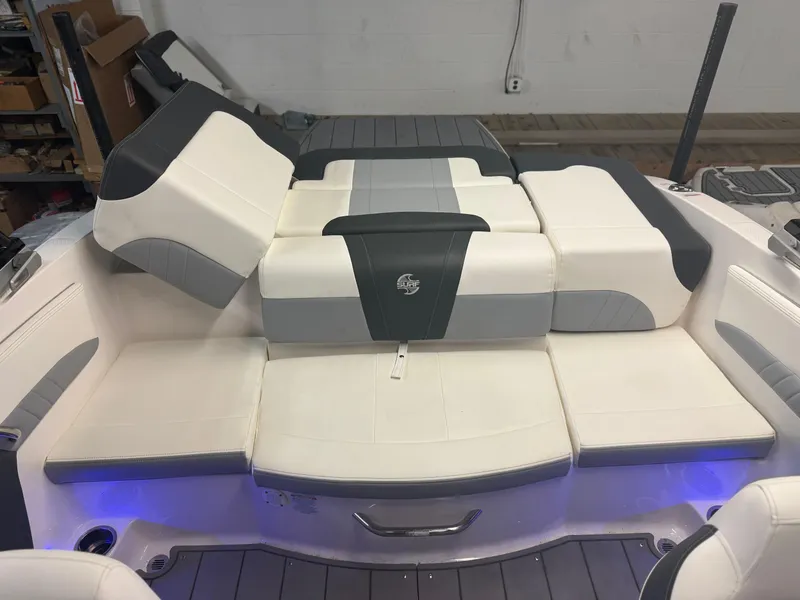 Slide: The Image of 2023 Chaparral 21 Surf boat interior with cushioned seating and ambient lighting. - 15