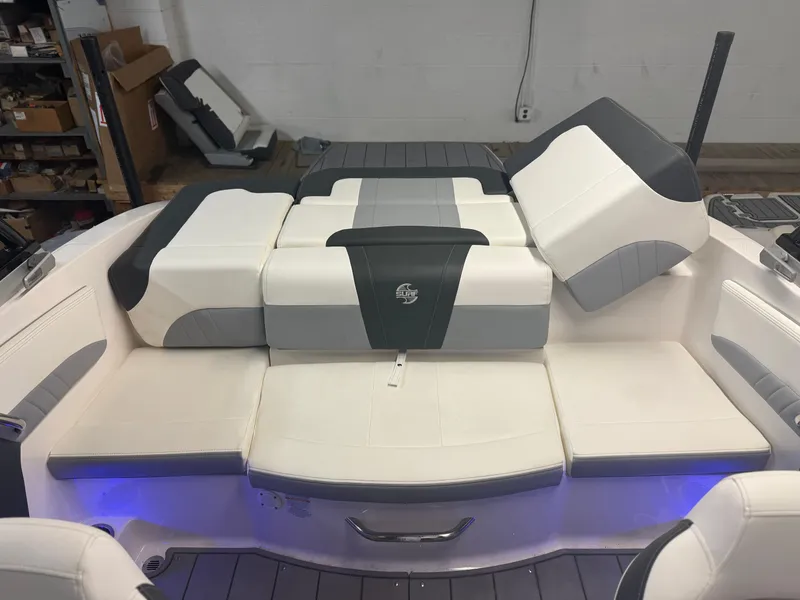 Slide: The Image of 2023 Chaparral 21 Surf boat interior with cushioned seating and ambient lighting. - 16