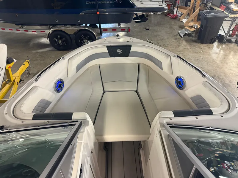 Slide: The Image of 2023 Chaparral 21 Surf boat interior with cushioned seating and blue speakers. - 4