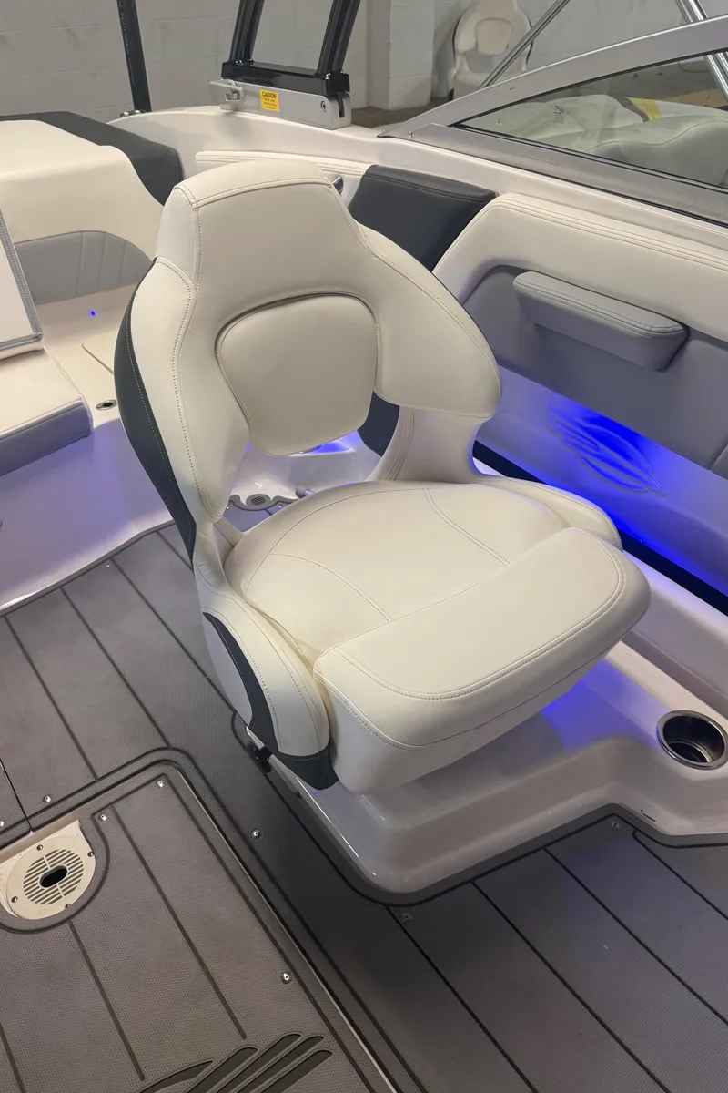 Slide: The Image of 2023 Chaparral 21 Surf boat interior with white captain's chair and blue accent lighting. - 6