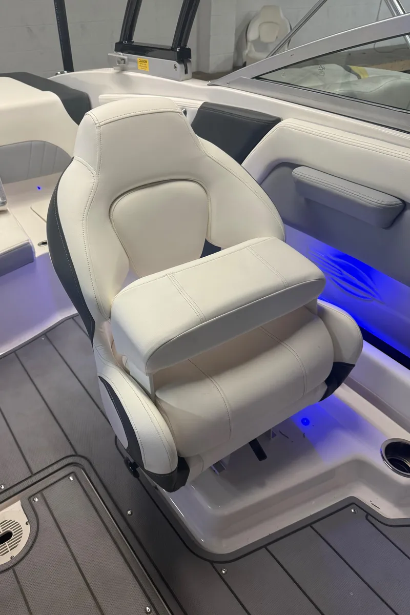 Slide: The Image of 2023 Chaparral 21 Surf boat interior with luxurious white seating and ambient blue lighting. - 7