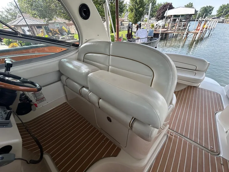 Slide: The Image of 2002 Sea Ray 300 Sundancer interior with white leather seating and wood-patterned flooring. - 14