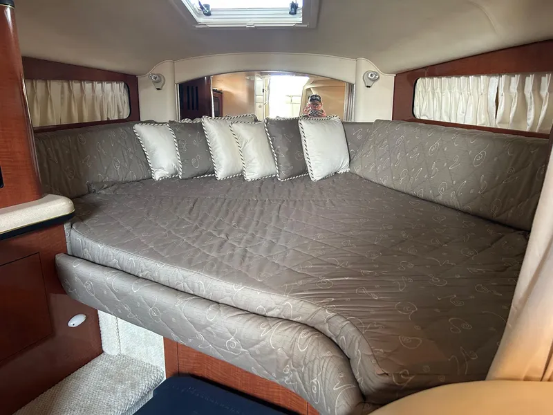 Slide: The Image of Interior cabin of 2002 Sea Ray 300 Sundancer with cushioned bed and pillows. - 21