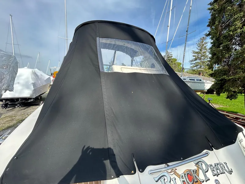 Slide: The Image of 2002 Sea Ray 300 Sundancer with black cover, docked outdoors. - 5