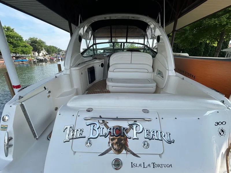 Slide: The Image of 2002 Sea Ray 300 Sundancer boat named "The Black Pearl" docked by a scenic waterfront. - 6