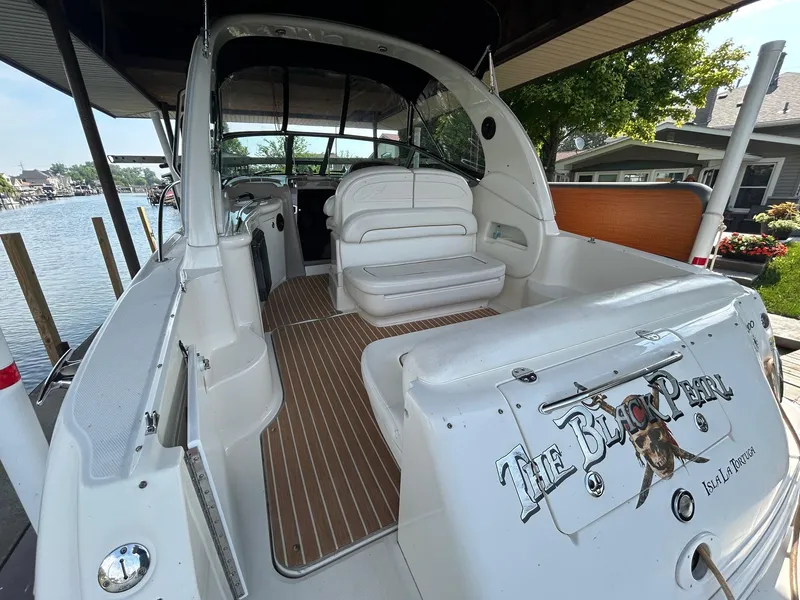 Slide: The Image of 2002 Sea Ray 300 Sundancer boat docked, featuring spacious seating and "The Black Pearl" decal. - 7