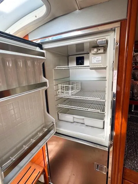 Slide: The Image of Open refrigerator inside a 2009 Formula 400ss boat, featuring wire shelves and door storage. - 39