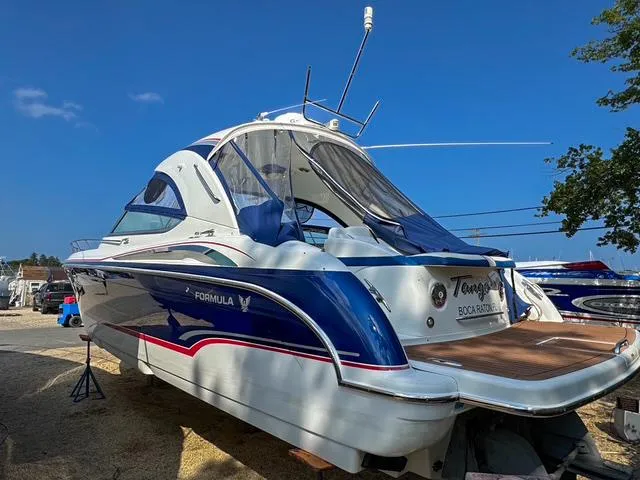 Slide: The Image of 2009 Formula 400ss boat with sleek design, docked under clear blue sky. - 9