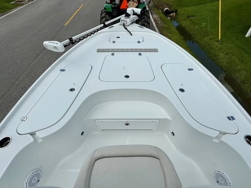 Slide: The Image of 2023 Sea Hunt BX22 boat deck with storage compartments and trolling motor on trailer. - 15