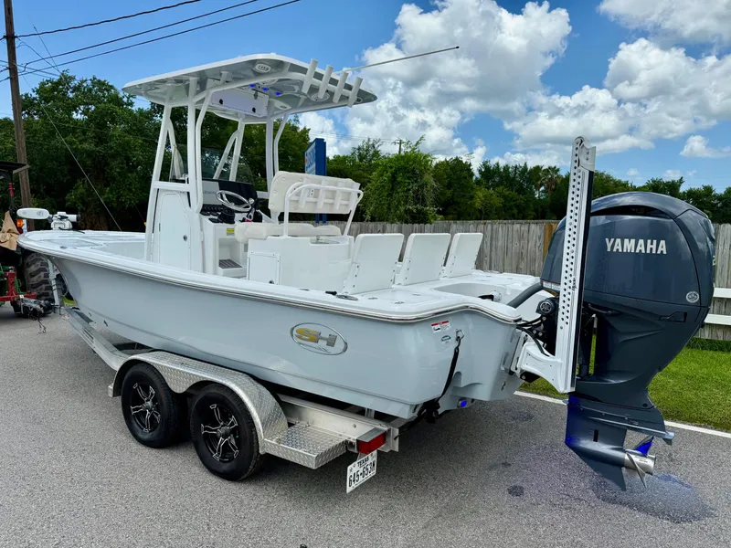Slide: The Image of 2023 Sea Hunt BX22 boat with Yamaha engine on a trailer, parked on a sunny day. - 2
