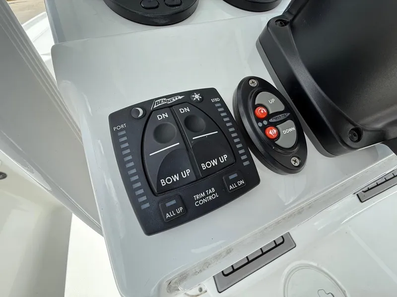 Slide: The Image of 2023 Sea Hunt BX22 boat control panel with trim tab and power pole buttons. - 22