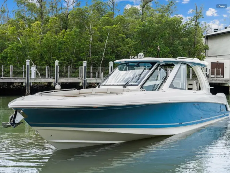 The Image of 2022 Boston Whaler 380 Realm boat docked near lush greenery. - 0
