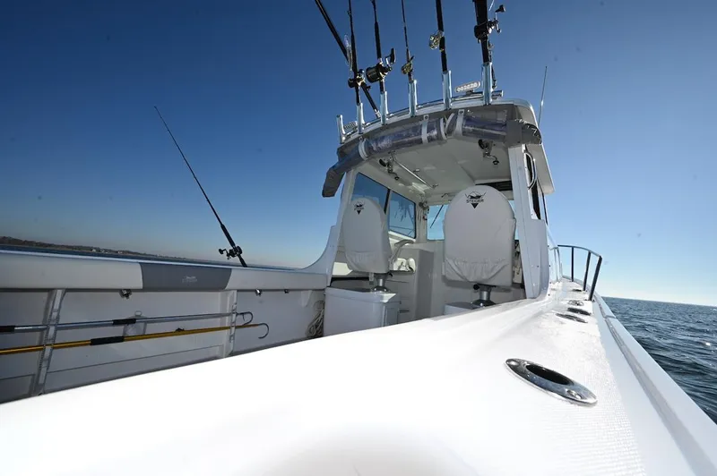 Slide: The Image of 2026 Steiger Craft 255 Miami boat with fishing rods, ocean view, and clear sky. - 14