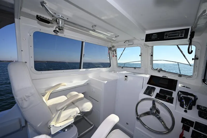 Slide: The Image of Interior of 2026 Steiger Craft 255 Miami boat with steering wheel and ocean view. - 6