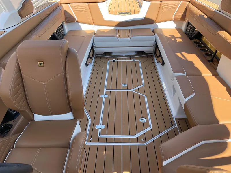 Slide: The Image of 2025 Nautique Super Air Nautique G25 interior with tan leather seating and teak-style flooring. - 12