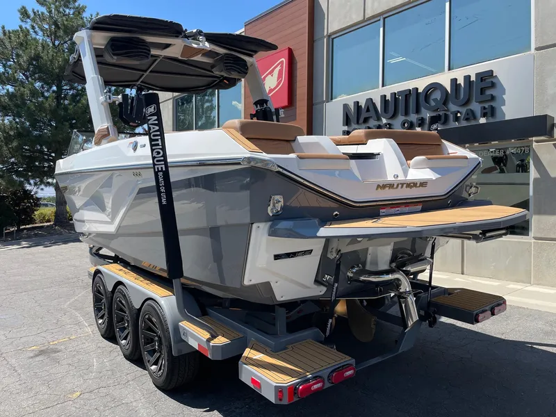 Slide: The Image of 2025 Nautique Super Air Nautique G25 boat on trailer outside dealership. - 3