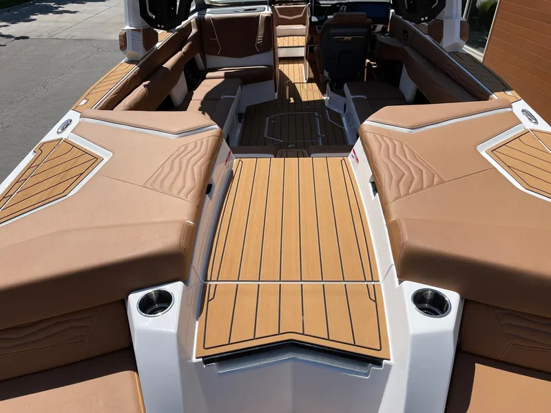 Slide: The Image of 2025 Nautique Super Air Nautique G25 interior with tan upholstery and wood accents. - 4