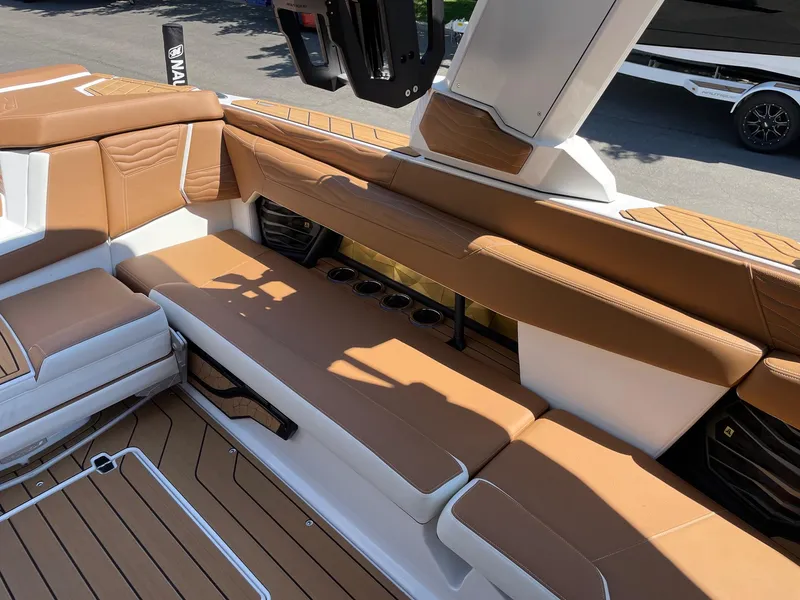 Slide: The Image of 2025 Nautique Super Air Nautique G25 interior with tan leather seating and cup holders. - 9