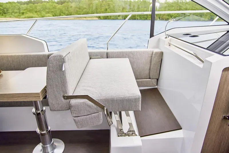 Slide: The Image of 2024 Sealine C335V interior with adjustable seating and table, overlooking water. - 11