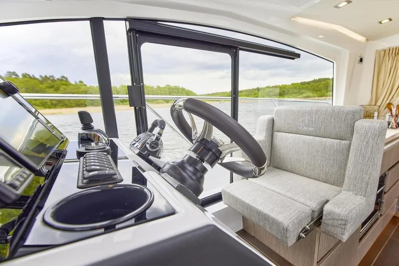Slide: The Image of 2024 Sealine C335V yacht interior helm with modern steering and controls. - 13