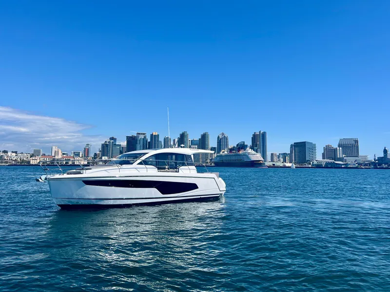 Slide: The Image of 2024 Sealine C335V yacht cruising in a city harbor with skyline backdrop. - 4