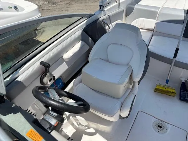 Slide: The Image of 2019 Chaparral 210 Deluxe boat interior with steering wheel and white seating. - 10