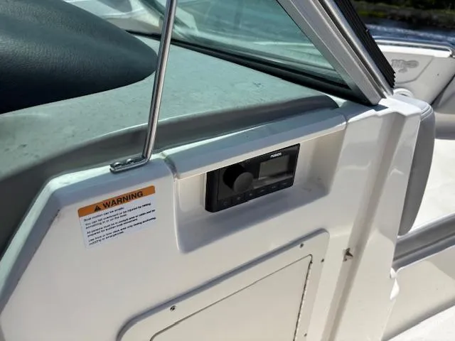 Slide: The Image of 2019 Chaparral 210 Deluxe boat interior with stereo system and warning label. - 18