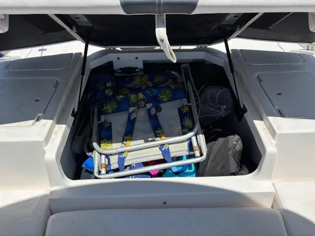 Slide: The Image of Open storage compartment in 2019 Chaparral 210 Deluxe boat with beach chairs and gear. - 20