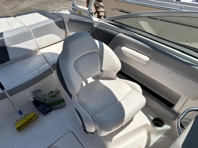 Slide: The Image of 2019 Chaparral 210 Deluxe boat interior with white seating and steering area. - 9